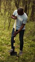 Team of activists planting trees to conserve natural ecosystem and forest environment, digging holes after collecting rubbish. Volunteers taking action and preserving the woods habitat. Camera B. video