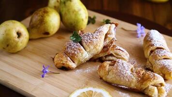 Sweet pastries, puff pastries with pears, on a wooden table video