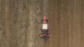 superiore Visualizza di trattore straziante suolo nel agricolo campo. video