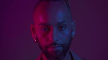 une homme avec une barbe et une mohawk est portant une chemise avec une violet Contexte video