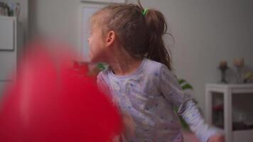 uma pequeno menina é jogando com uma vermelho balão video