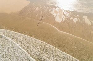 two people on the shore of a beach during low tide, aerial view with drone. Summer holidays concept photo