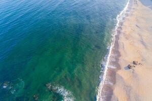 parte superior aéreo ver de el apuntalar de un vacío playa en verano a amanecer, zumbido Disparo foto