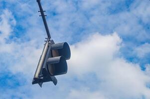 un advertencia tráfico ligero con un nublado azul cielo antecedentes foto