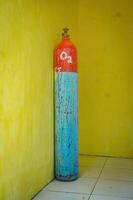 an oxygen cylinder isolated on yellow wall. Perfect for medical content. photo