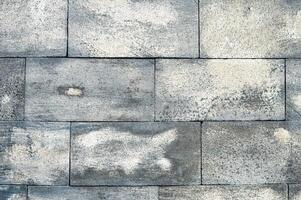 The road is paved with gray stones, top view. stone texture, outdoor stone tiles. neatly arranged pattern of andesite stone wallsq photo