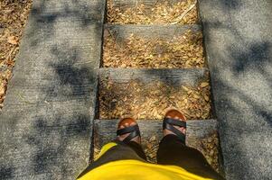 feet of a man wearing sports clothes walking down the stairs photo