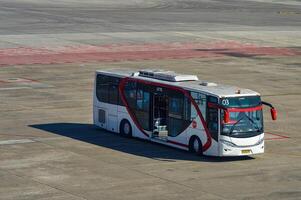 an airport bus belonging to the airline air asia prepares to pick up passengers who get off the plane at the apron of juanda international airport, Indonesia, 29 July 2023. photo