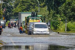 varios vehículos tal como camiones, bicicletas y carros fueron atrapado por agua de inundación en griego regencia, Indonesia, 21 febrero 2024. foto