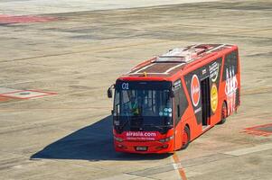 an airport bus belonging to the airline air asia prepares to pick up passengers who get off the plane at the apron of juanda international airport, Indonesia, 29 July 2023. photo
