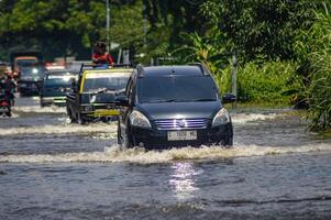 varios vehículos tal como camiones, bicicletas y carros fueron atrapado por agua de inundación en griego regencia, Indonesia, 21 febrero 2024. foto