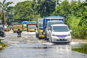 varios vehículos tal como camiones, bicicletas y carros fueron atrapado por agua de inundación en griego regencia, Indonesia, 21 febrero 2024. foto