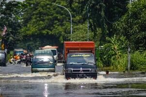 varios vehículos tal como camiones, bicicletas y carros fueron atrapado por agua de inundación en griego regencia, Indonesia, 21 febrero 2024. foto