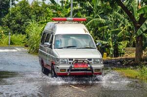 an ambulance passing through flood waters in Gresik Regency, Indonesia, 21 February 2024. photo