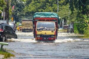 varios vehículos tal como camiones, bicicletas y carros fueron atrapado por agua de inundación en griego regencia, Indonesia, 21 febrero 2024. foto