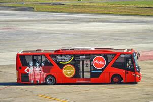 an airport bus belonging to the airline air asia prepares to pick up passengers who get off the plane at the apron of juanda international airport, Indonesia, 29 July 2023. photo