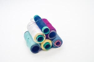 pile of rolls of colorful sewing thread with copy space isolated on white background photo