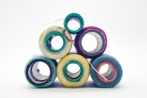 pile of rolls of colorful sewing thread with copy space isolated on white background photo