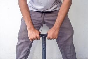 an adult man who is pumping a bicycle as hard as he can using a manual pump photo