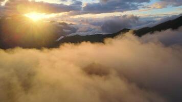 Dom brilla mediante nubes terminado montaña paisaje, creando un calma atmósfera video