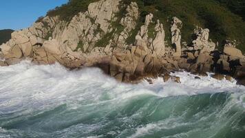 furioso mare nel il mattina a alba onde rotolo su il roccioso riva spray vola in il cielo video