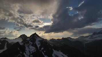 Sunbeam piercing through cloudy sky above mountain landscape video