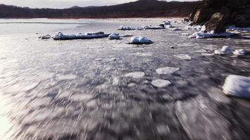 aéreo ver derritiendo hielo cerca escabroso Oceano rocas naturaleza belleza derritiendo hielo vívido recordatorio de de la naturaleza fragilidad y belleza. derritiendo hielo rodeando virgen del Norte paisajes impresionante vista. video