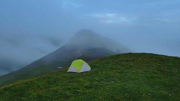 a tent is sitting on top of a grassy hill video