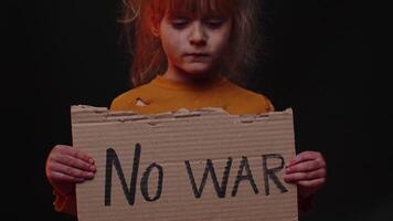 Upset poor toddler child girl homeless protesting war conflict raises banner with inscription No War video