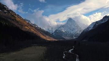 sereen schoonheid macht van natuur samenvoegen in majestueus berg voorbij gaan aan bewolkt lucht antenne visie vredig toevluchtsoord waar reflectie in berg voorbij gaan aan is uitgenodigd. volhardend charme sterkte tentoongesteld door berg slagen voor. video