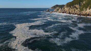 woedend zee in de ochtend- Bij dageraad golven rollen Aan de rotsachtig kust verstuiven stijgt in de lucht video