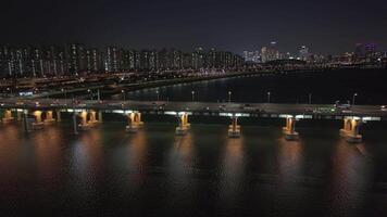 panoramico aereo Visualizza di Seoul han fiume a notte luccichii sotto città luci han fiume a notte vena attraverso metropoli riflette di seoul polso. lungo han fiume a notte di seoul cultura maestà svelare. video