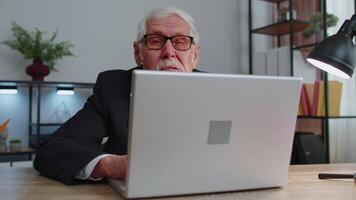 Senior mature older business man hiding behind laptop computer, making funny face, fooling around video