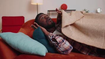 aterrorizado asustado africano americano joven hombre despierta arriba desde estrés pesadilla en dormitorio a hogar sofá video