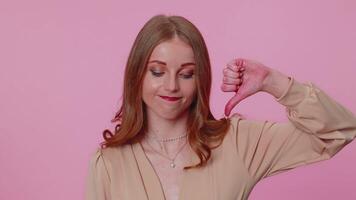 Upset girl in beige blouse showing thumbs down sign gesture, disapproval, dissatisfied, dislike video