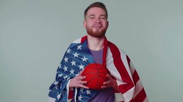 Bearded young man basketball fan holding American USA flag doing winner gesture, dancing alone video