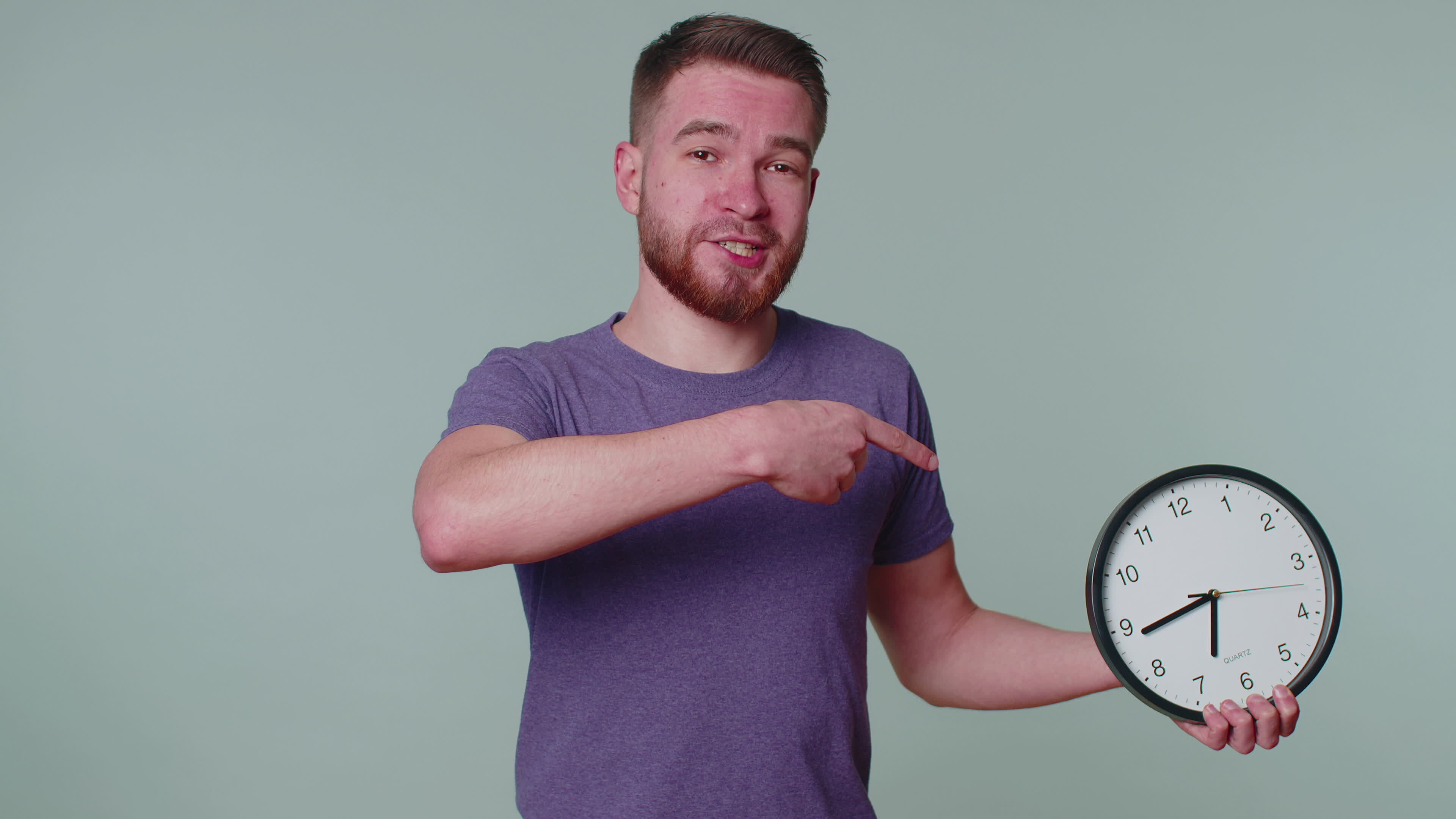 Bearded young man showing time on clock watch, ok, thumb up, approve ...