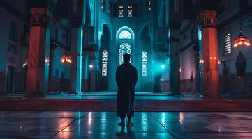 Muslim man standing praying on night in the mosque photo