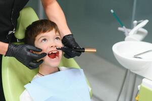 Close-up of little boy opening his mouth during dental checkup photo