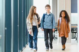 Group of elementary school kids in a school corridor photo