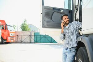 Indian truck driver tending a client on the phone photo