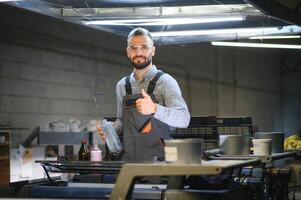 printing house, experimented technician works on UV printer. Production work photo