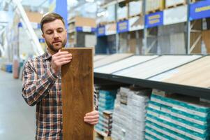 Middle age man choosing floor laminate for his home photo