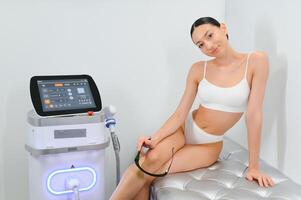 Young woman making body hair removal laser depilation in beauty center photo