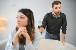 An agitated and upset husband shouts and looks at his wife, a quarrel between spouses. Family misunderstanding, quarrel photo