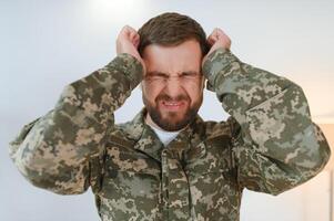 Depressed man recalling war days. Portrait of veteran soldier who has PTSD photo