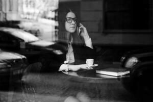 Young businesswoman talking on the phone in coffee shop photo