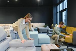 Couple choosing sofa and pillows at furniture store photo