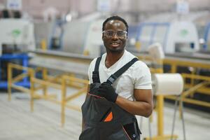 Industrial worker indoors in factory. Young technician with orange hard hat photo