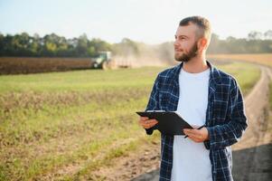 Agriculture. farmer working in a field in the background tractor plows ground in a field of wheat. farming agriculture concept. business farmer in the field photo